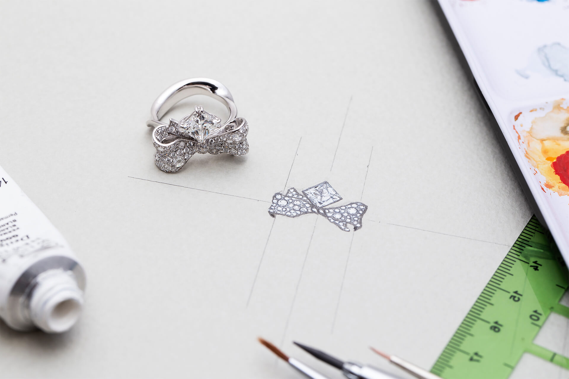 此珠寶設計以「彼此的禮物」為概念發想，以蝴蝶結和緞帶造型作為週年結婚對戒主軸